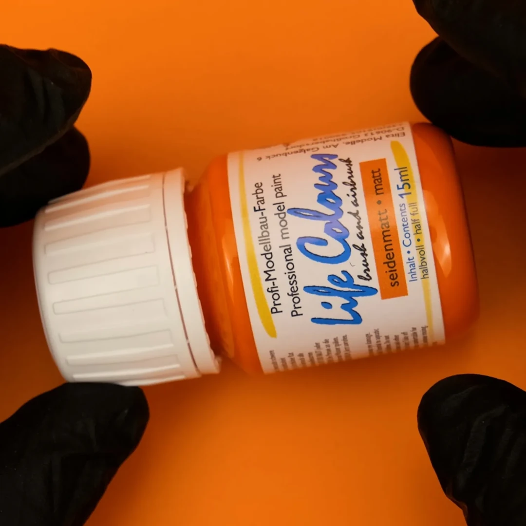 Life Colours Blutorange wird von Händen in schwarzen Handschuhen gehalten