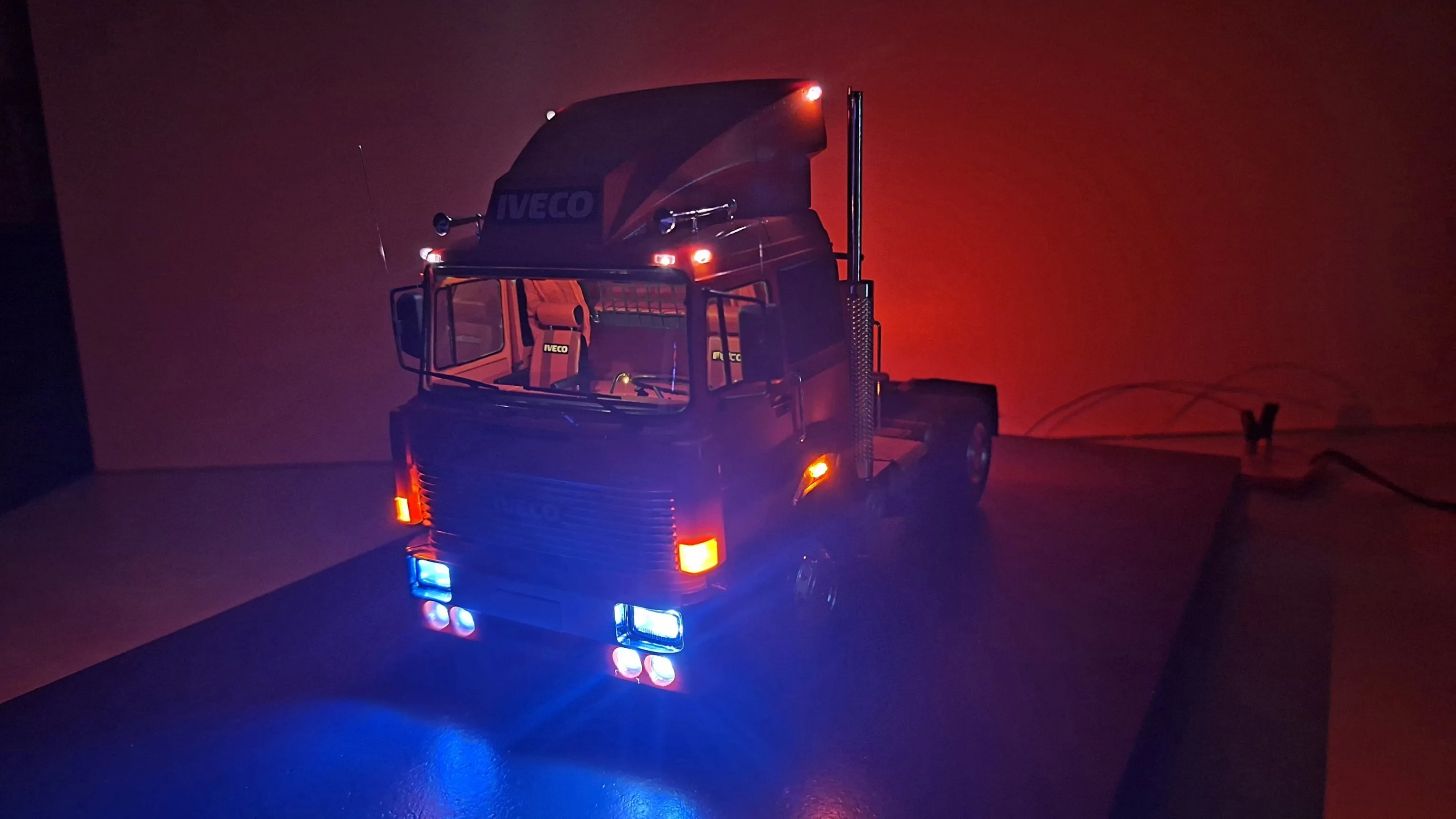Detailaufnahme des Iveco 190-38 T Special Modelltrucks im Maßstab 1:24 im Dunkeln mit LED Lichtern an.